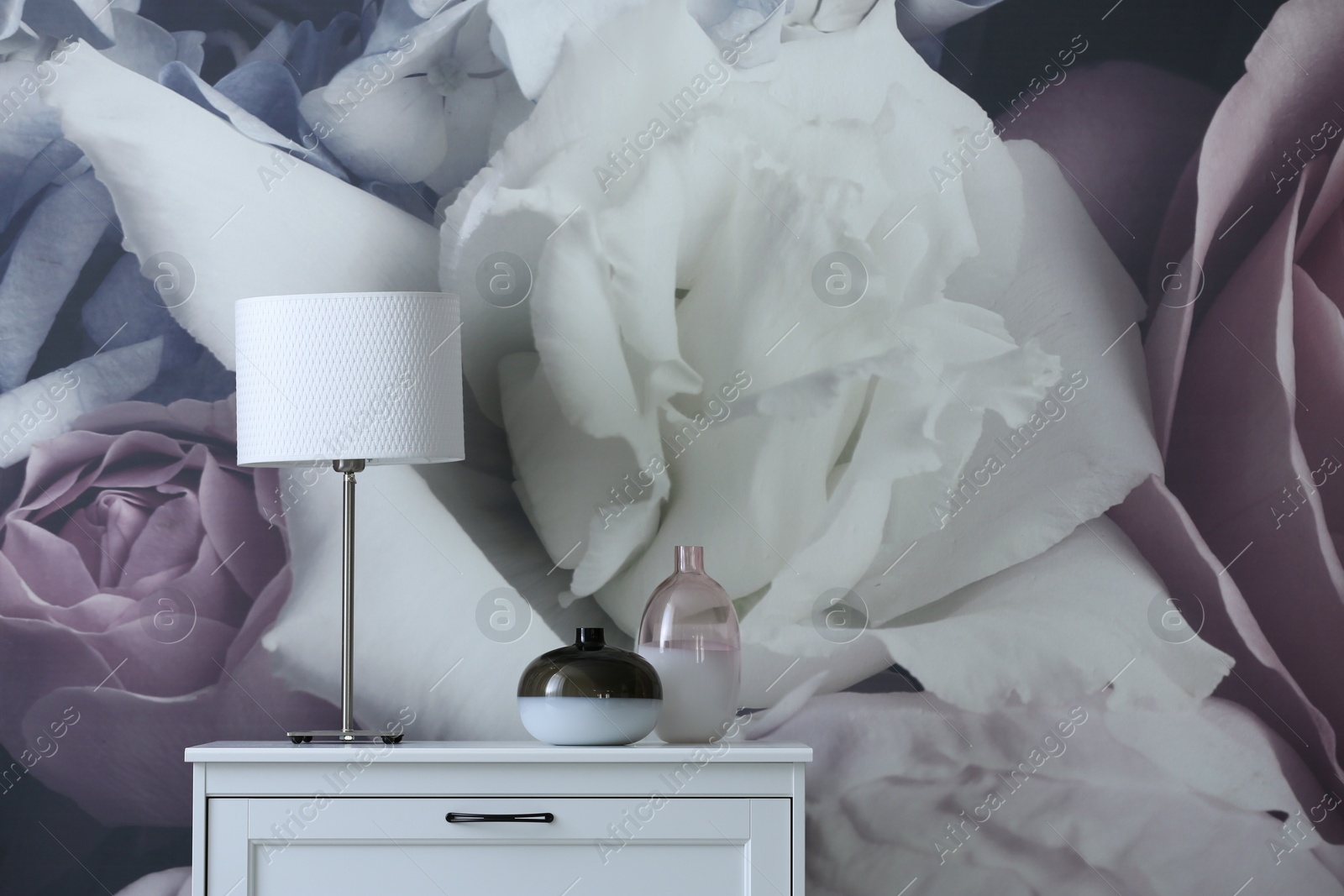 Photo of Stylish chest of drawers near painted wall in living room