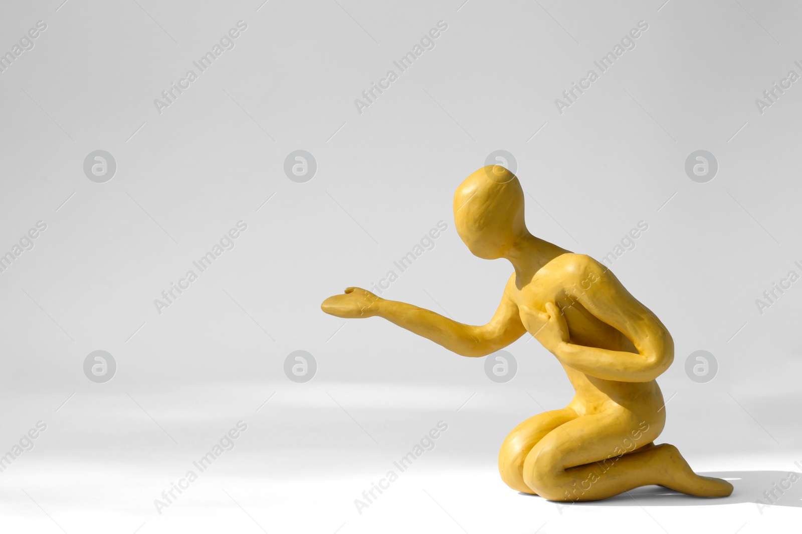 Photo of Plasticine figure of human asking help on white background. Space for text