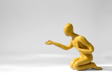 Photo of Plasticine figure of human asking help on white background. Space for text