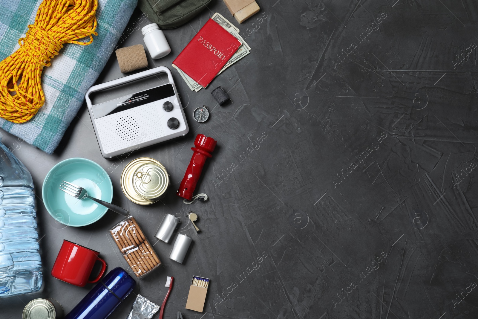 Photo of Earthquake supply kit on dark grey table, flat lay. Space for text