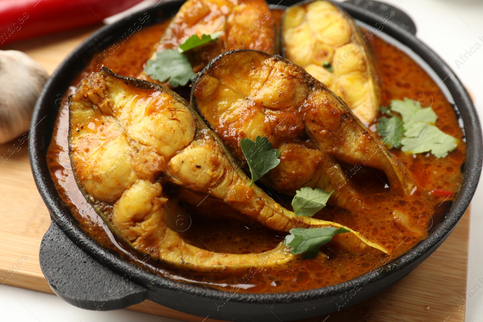 Photo of Tasty fish curry on table, closeup. Indian cuisine