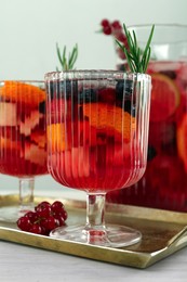 Photo of Glasses of Red Sangria on white wooden table, closeup