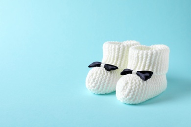 Handmade baby booties on color background. Space for text