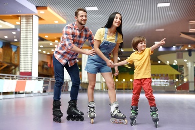 Happy family spending time at roller skating rink