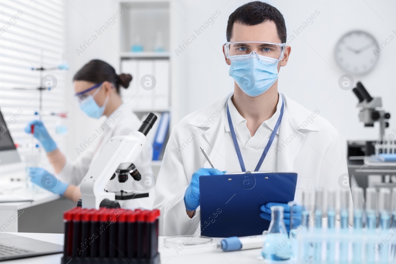 Photo of Scientist working with laboratory test form at table indoors