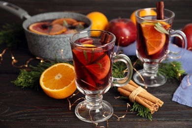 Photo of Tasty mulled wine with spices on wooden table