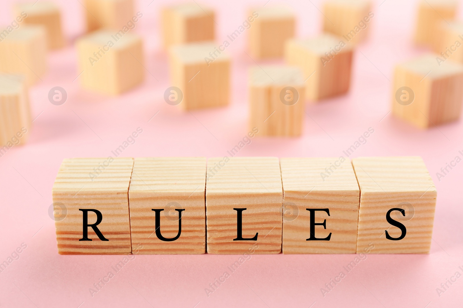 Photo of Word Rules made of wooden cubes with letters on pink background