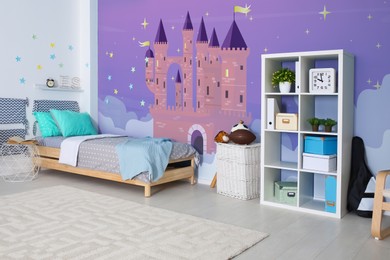 Image of Kid's room interior with comfortable bed. Fairytale themed wallpapers with castle