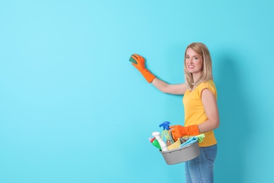 Woman in gloves cleaning color wall with sponge