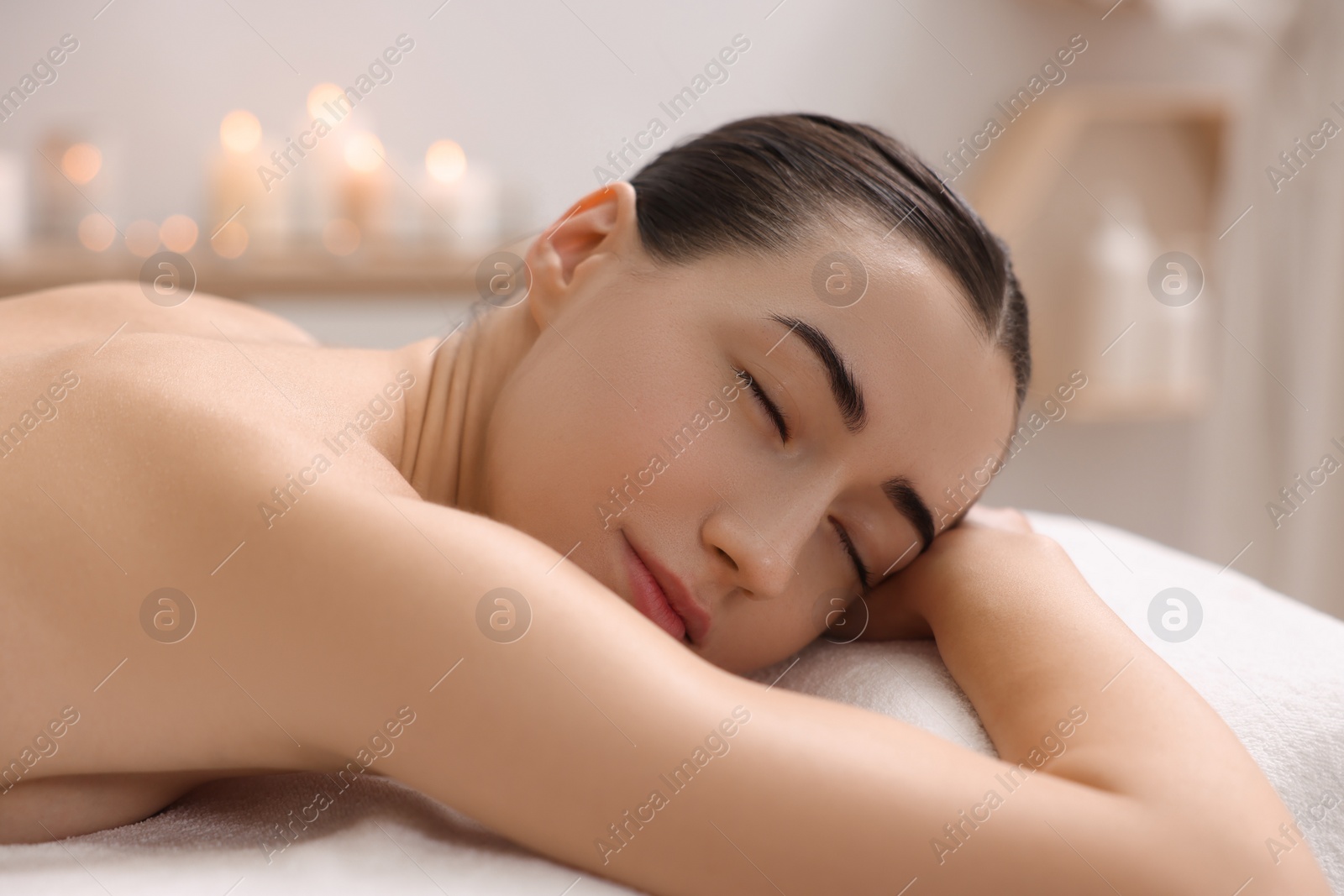 Photo of Beautiful woman relaxing on massage couch in spa salon