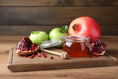 Honey, pomegranate and apples on wooden table. Rosh Hashana holiday