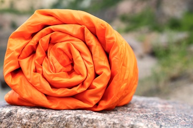 Photo of Rolled sleeping bag outdoors on sunny day, closeup