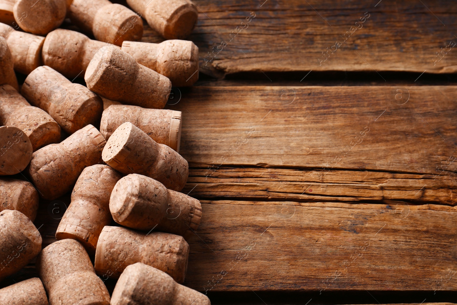 Photo of Sparkling wine bottle corks on wooden table. Space for text