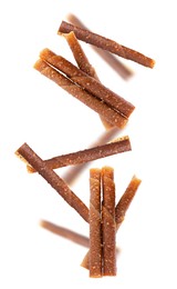 Delicious fruit leather rolls falling on white background