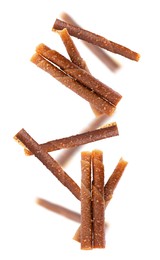 Image of Delicious fruit leather rolls falling on white background