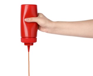 Woman pouring tasty ketchup from bottle on white background, closeup