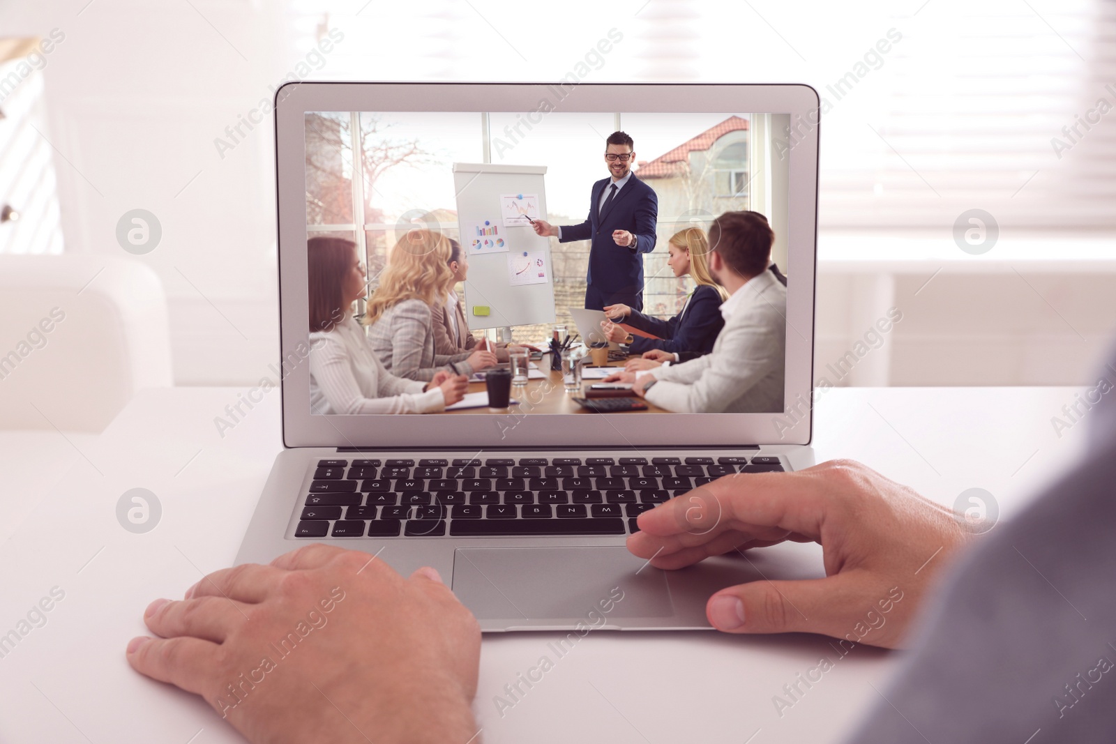 Image of Man attending online video conference via modern laptop at table, closeup