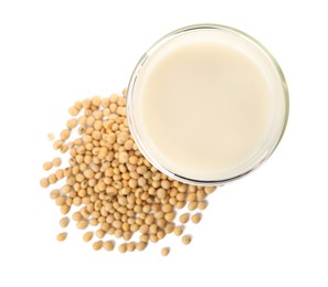 Photo of Glass of fresh soy milk and beans on white background, top view