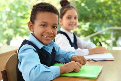 Photo of African-American boy wearing new school uniform in classroom