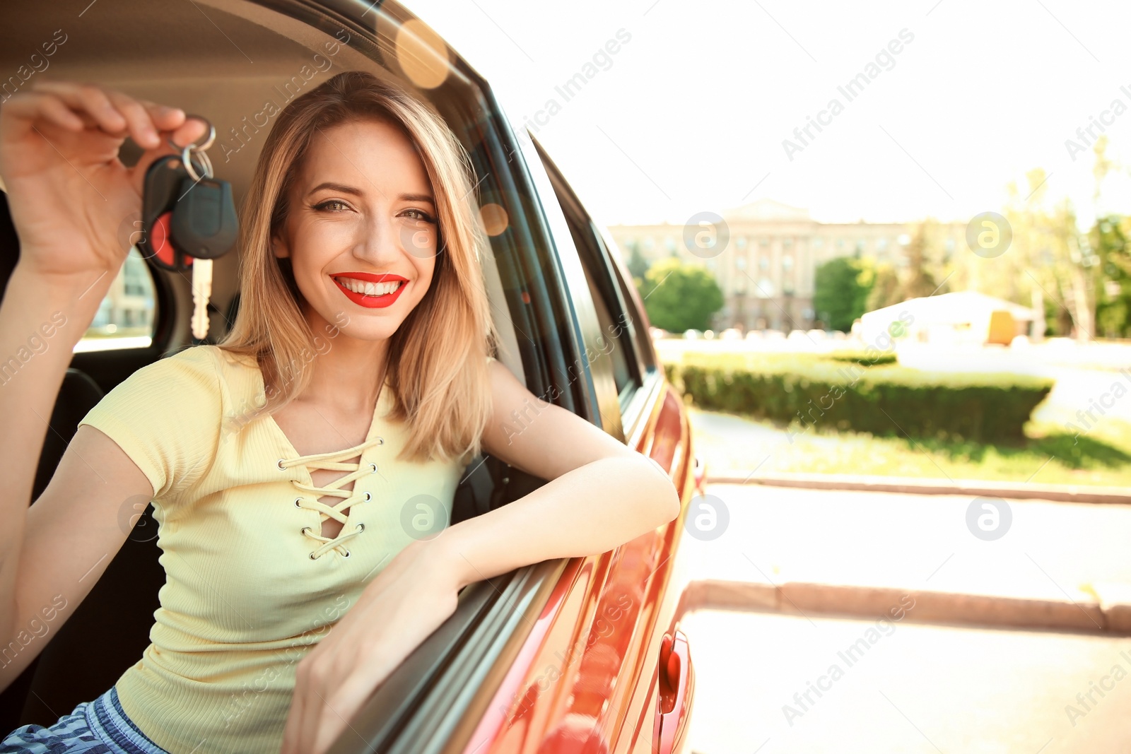 Photo of Young woman with car key on driver's seat of automobile