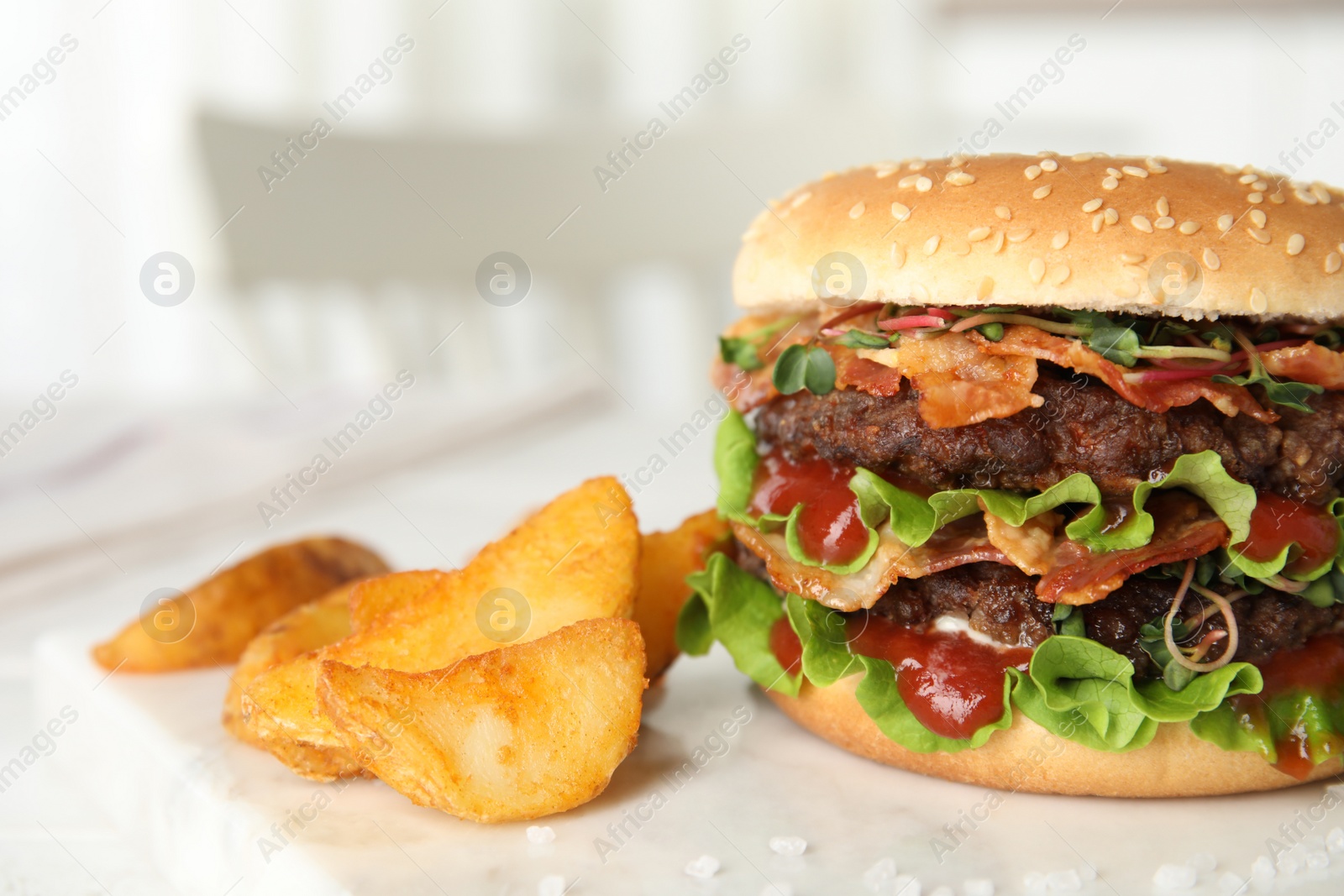 Photo of Tasty burger with bacon and fried potatoes on table, closeup. Space for text