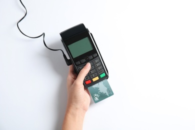 Photo of Woman using modern payment terminal on white background, top view. Space for text