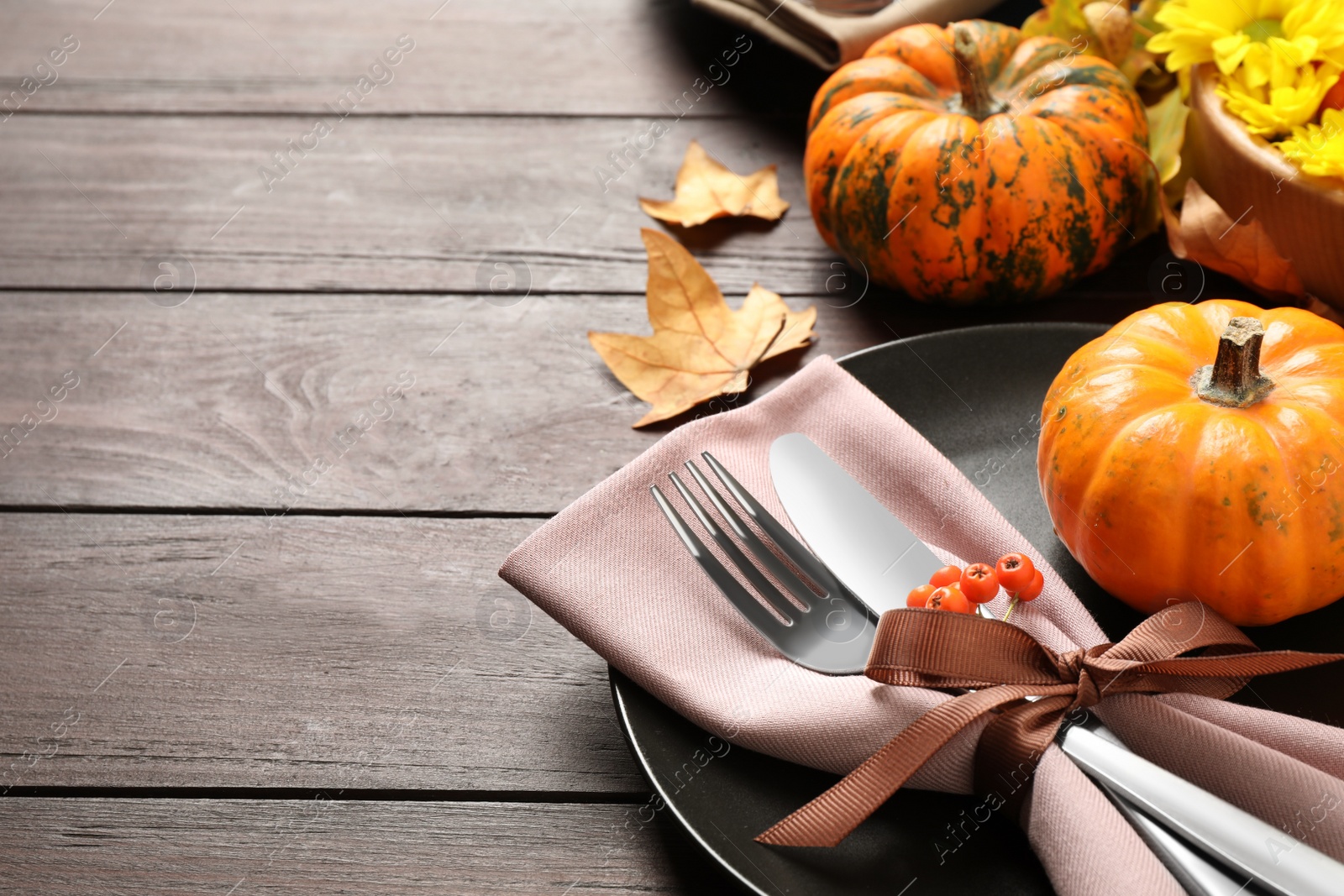 Photo of Festive table setting with autumn decor and space for text on wooden background, closeup. Thanksgiving Day celebration