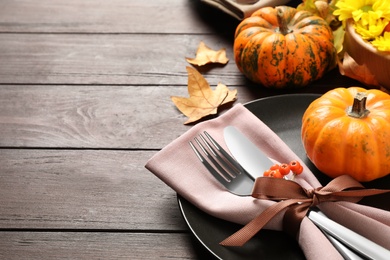 Photo of Festive table setting with autumn decor and space for text on wooden background, closeup. Thanksgiving Day celebration
