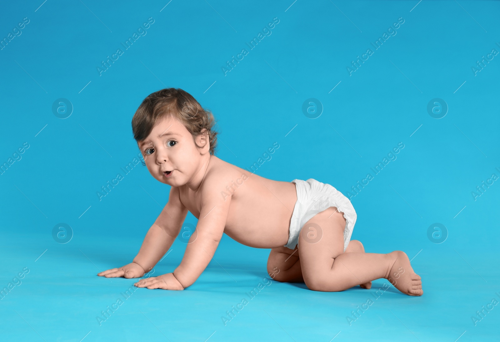 Photo of Cute little baby in diaper on light blue background