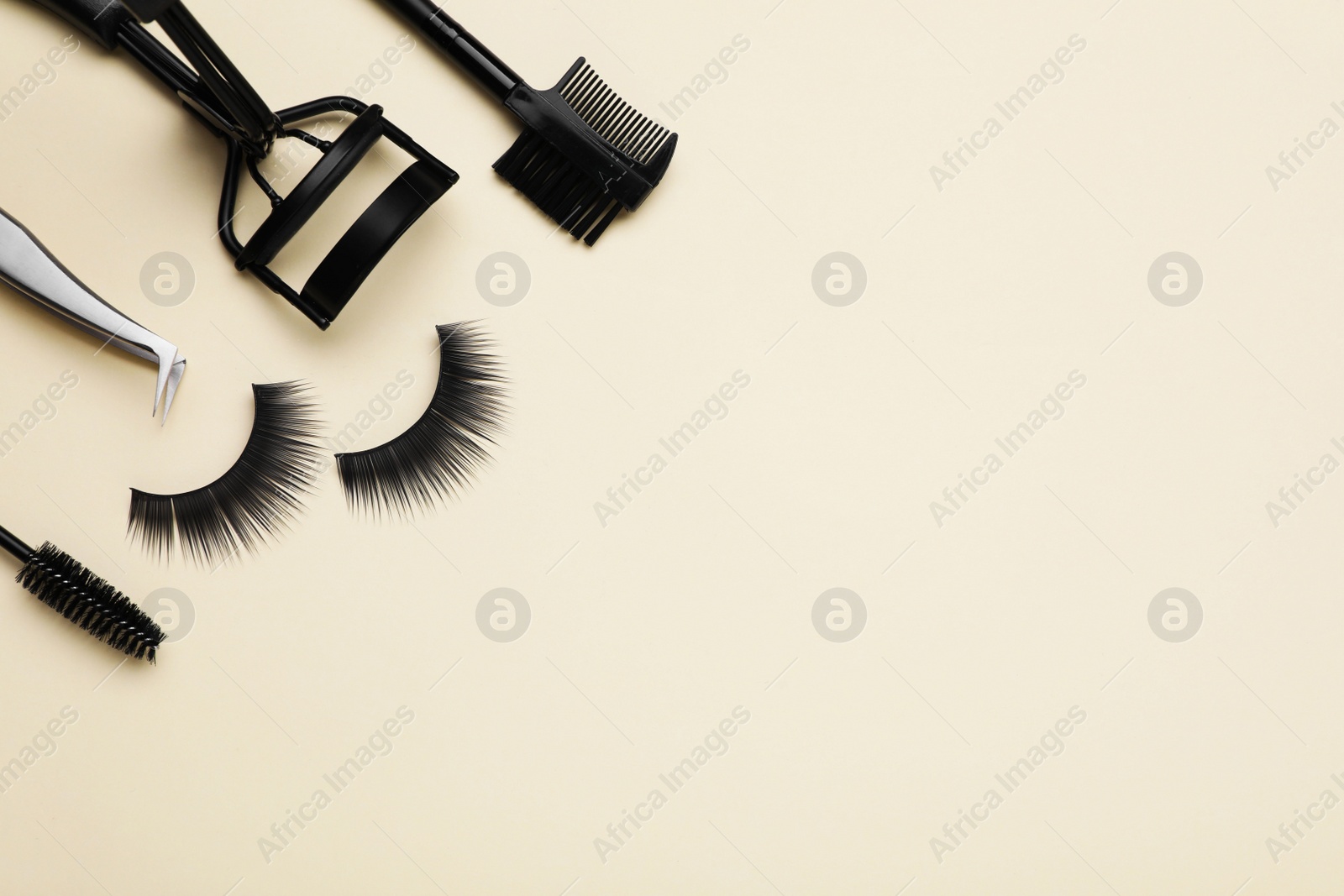 Photo of Flat lay composition with fake eyelashes on beige background, space for text