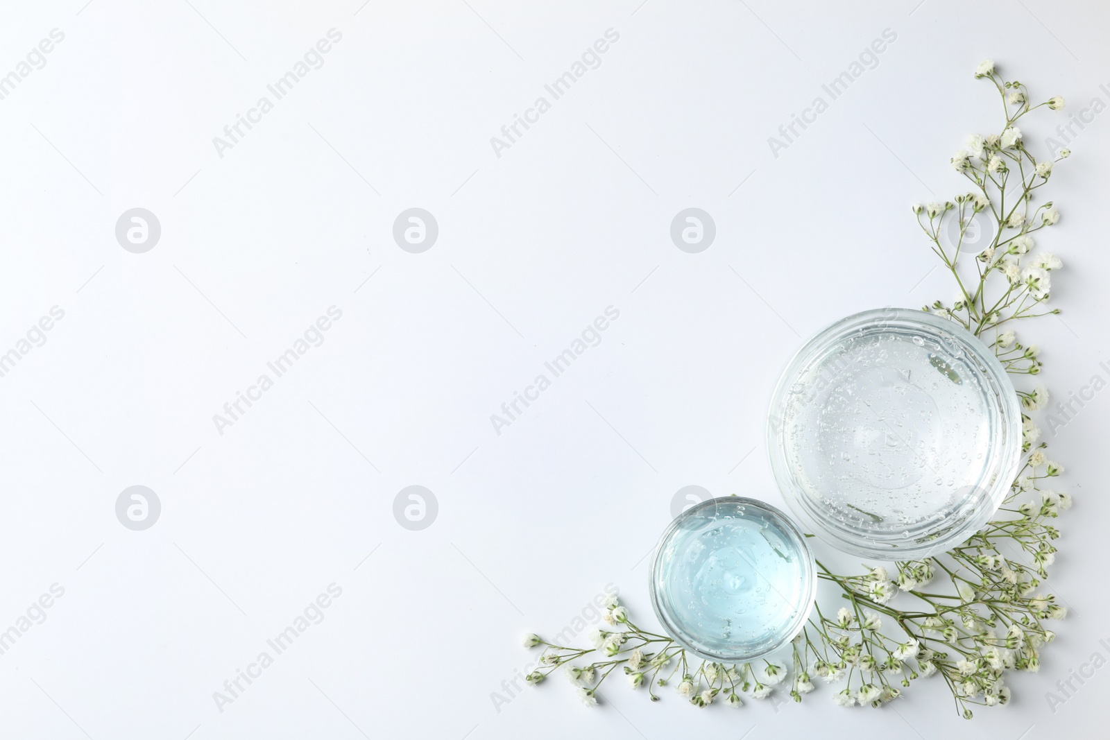 Photo of Composition with cosmetic gel and beautiful flowers on white background, top view