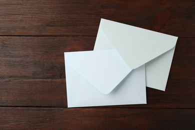 Photo of White paper envelopes on wooden table, top view