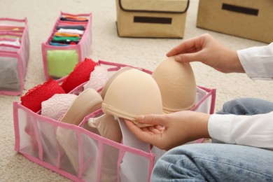 Woman folding clothes on floor, closeup. Japanese storage system