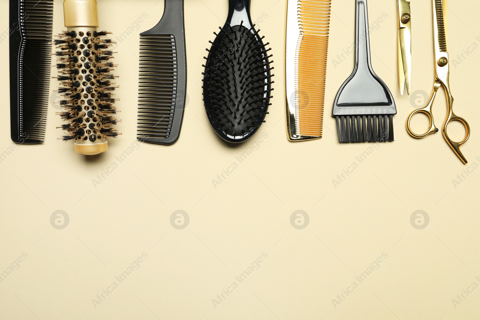 Photo of Hairdressing tools on beige background, flat lay. Space for text