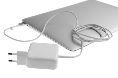 Photo of Laptop and charger on white background. Modern technology