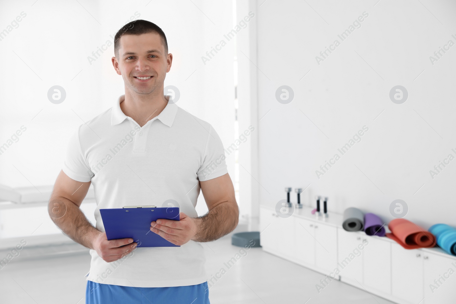 Photo of Portrait of professional physiotherapist with clipboard in rehabilitation center. Space for text