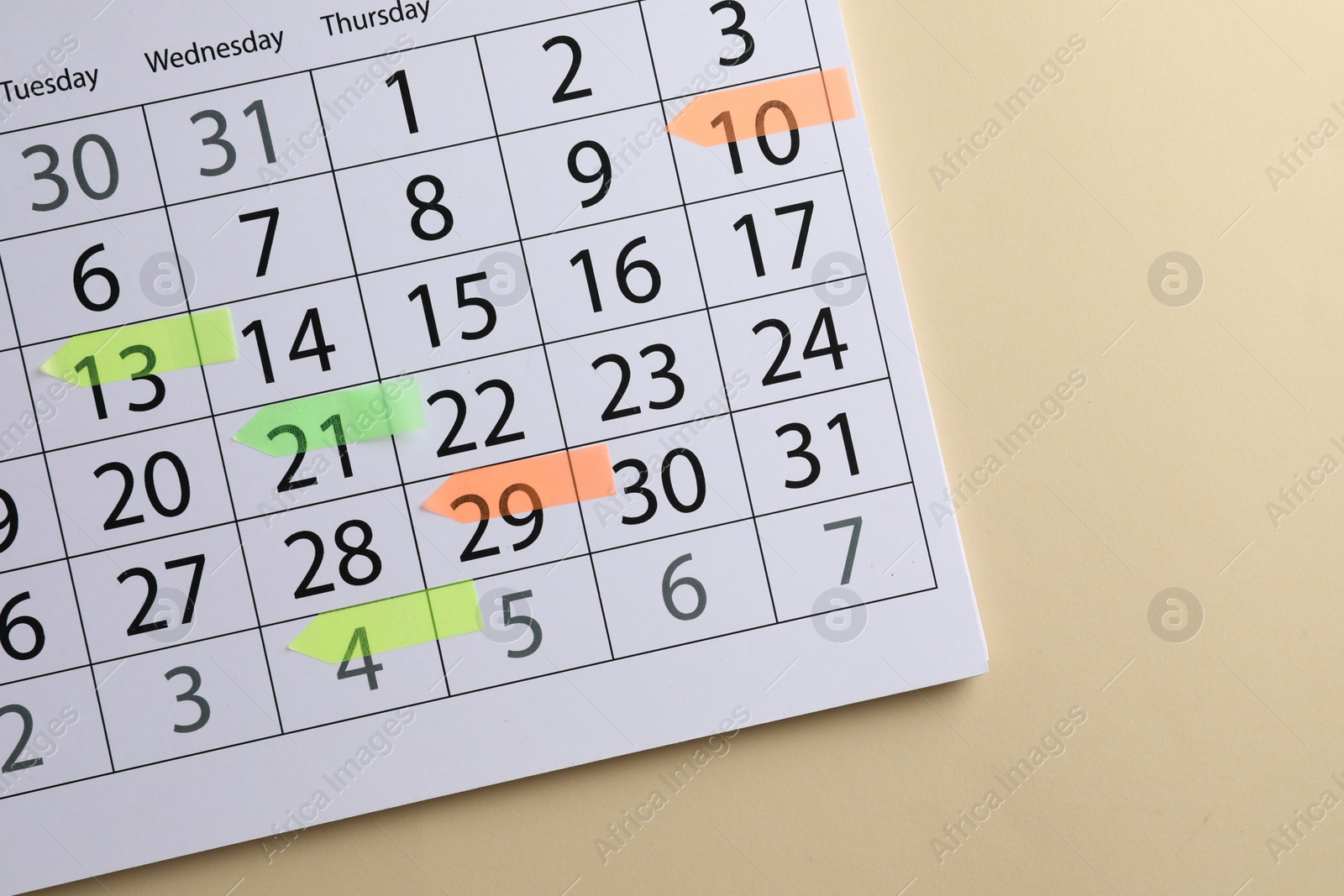 Photo of Timetable. Calendar page with colorful sticky notes on beige background, top view