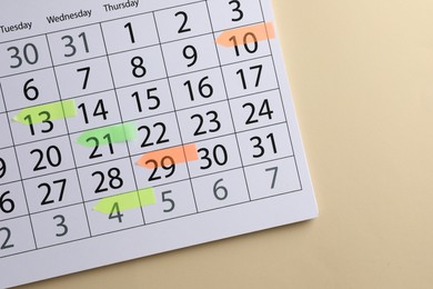 Photo of Timetable. Calendar page with colorful sticky notes on beige background, top view