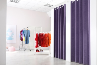 Photo of Fashion store interior with dressing rooms. Modern design