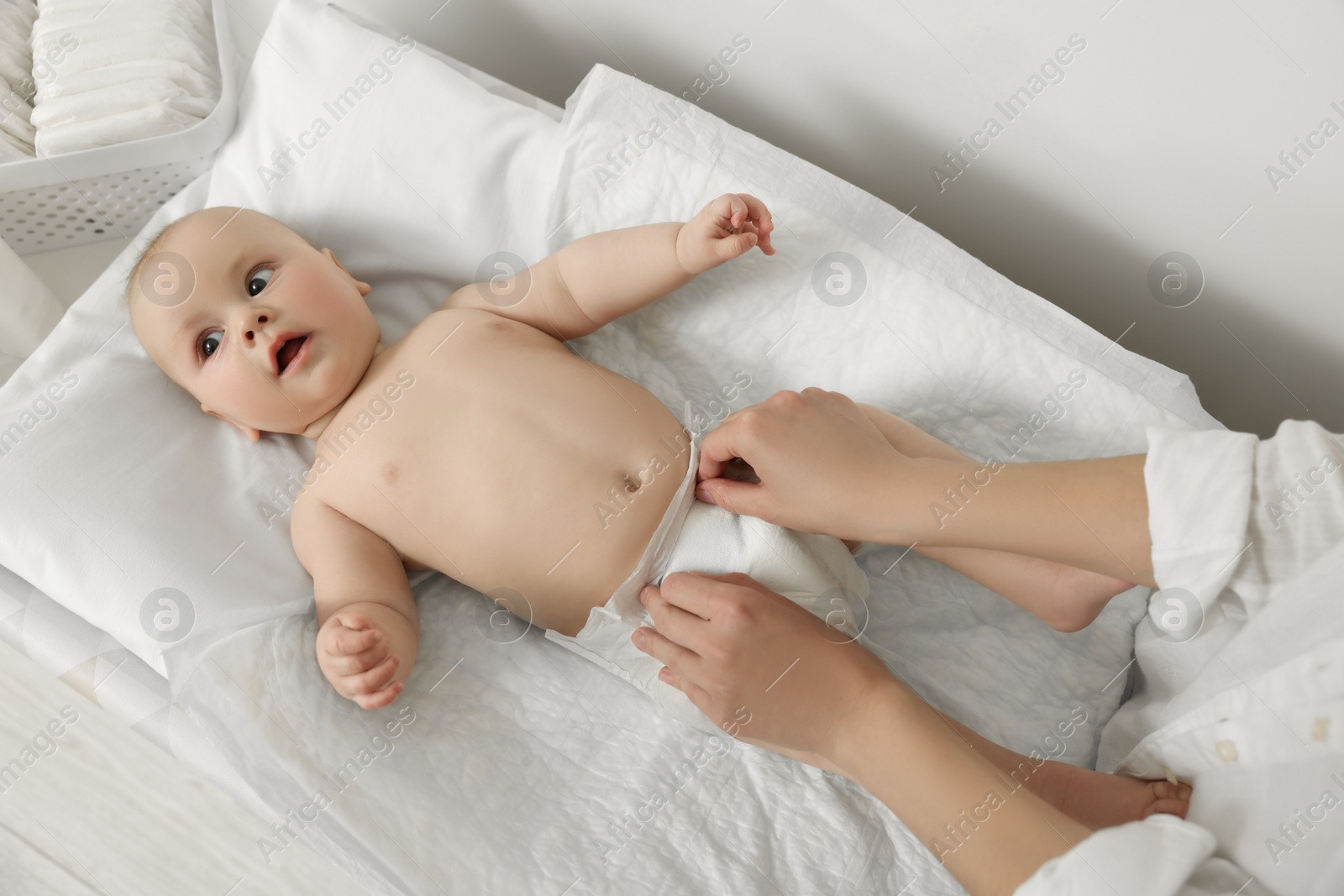 Photo of Mother changing her baby's diaper on table, closeup