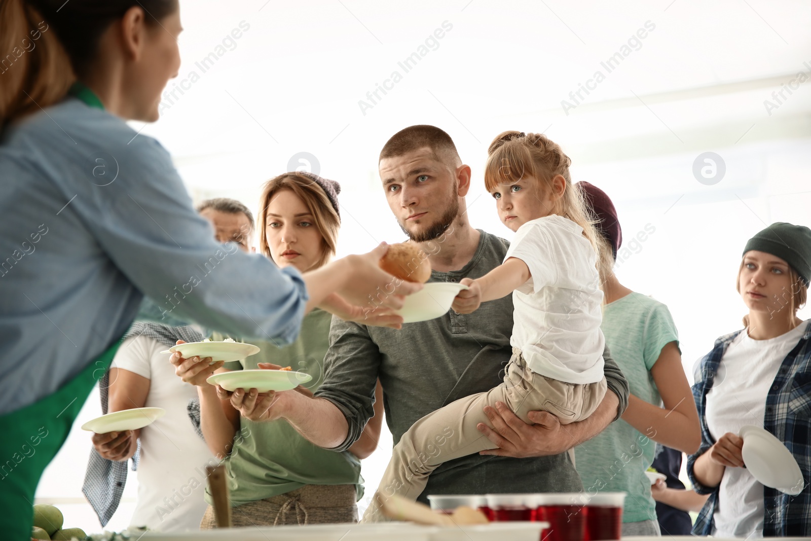 Photo of Volunteers serving food for poor people indoors