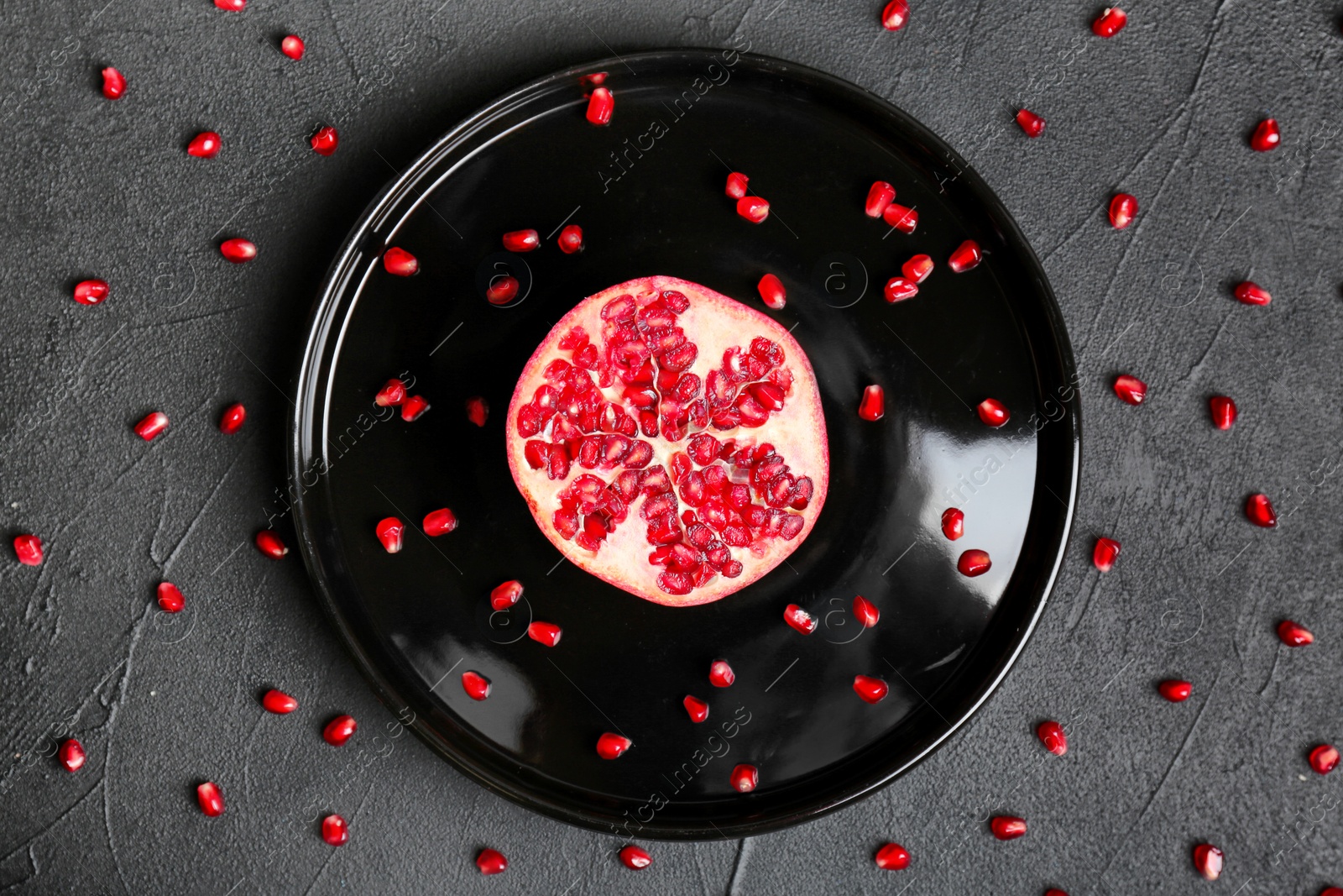 Photo of Plate with pomegranate on dark background