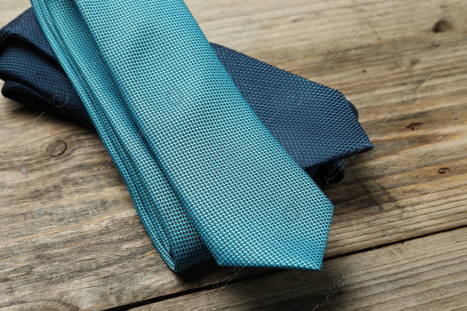 Photo of Two neckties on wooden table, closeup view