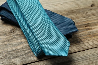 Photo of Two neckties on wooden table, closeup view