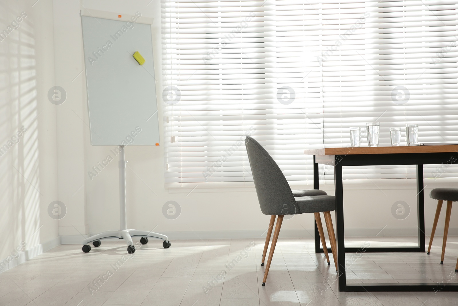 Photo of Conference room interior with wooden table and flipchart