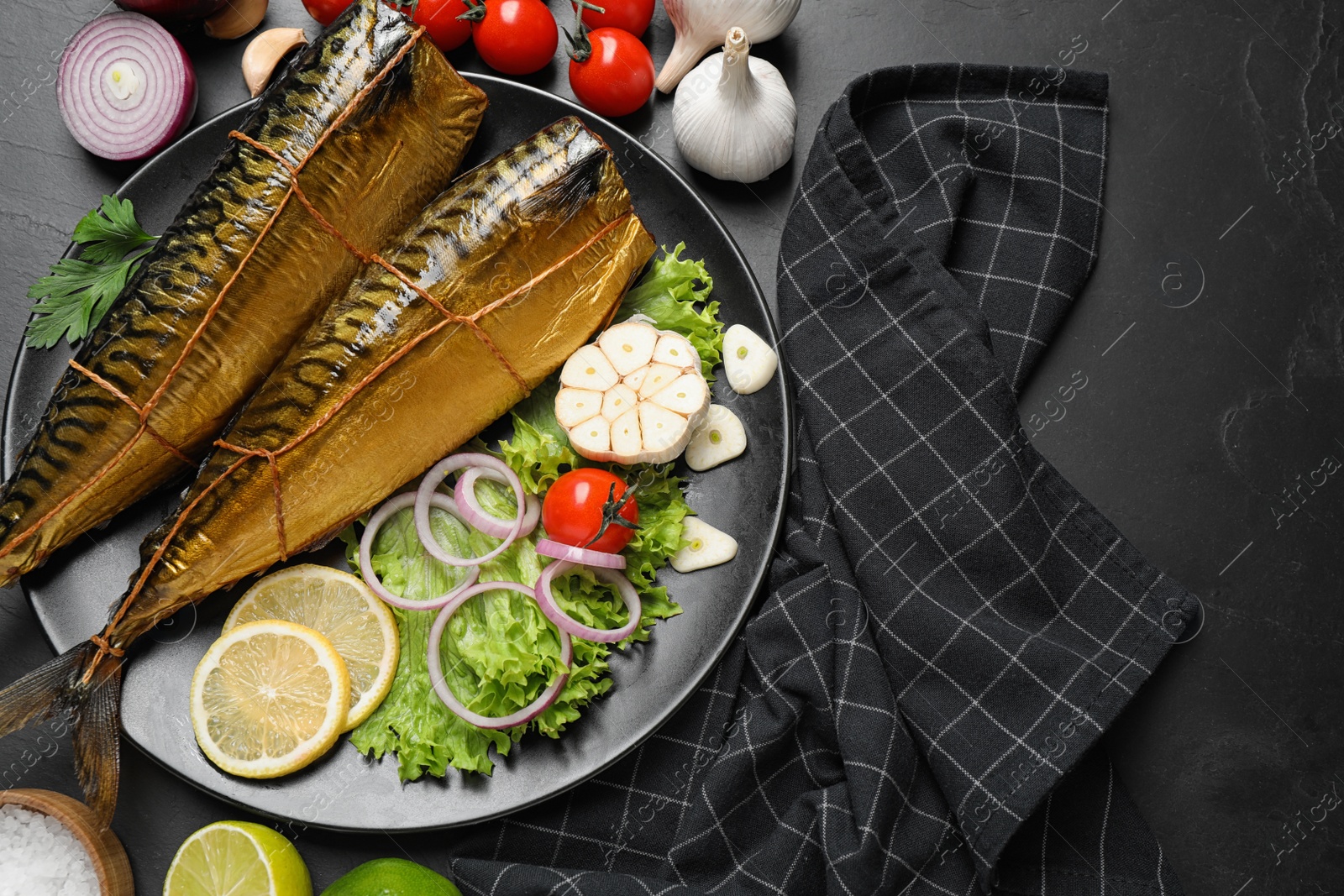 Photo of Flat lay composition with tasty smoked fish on dark table