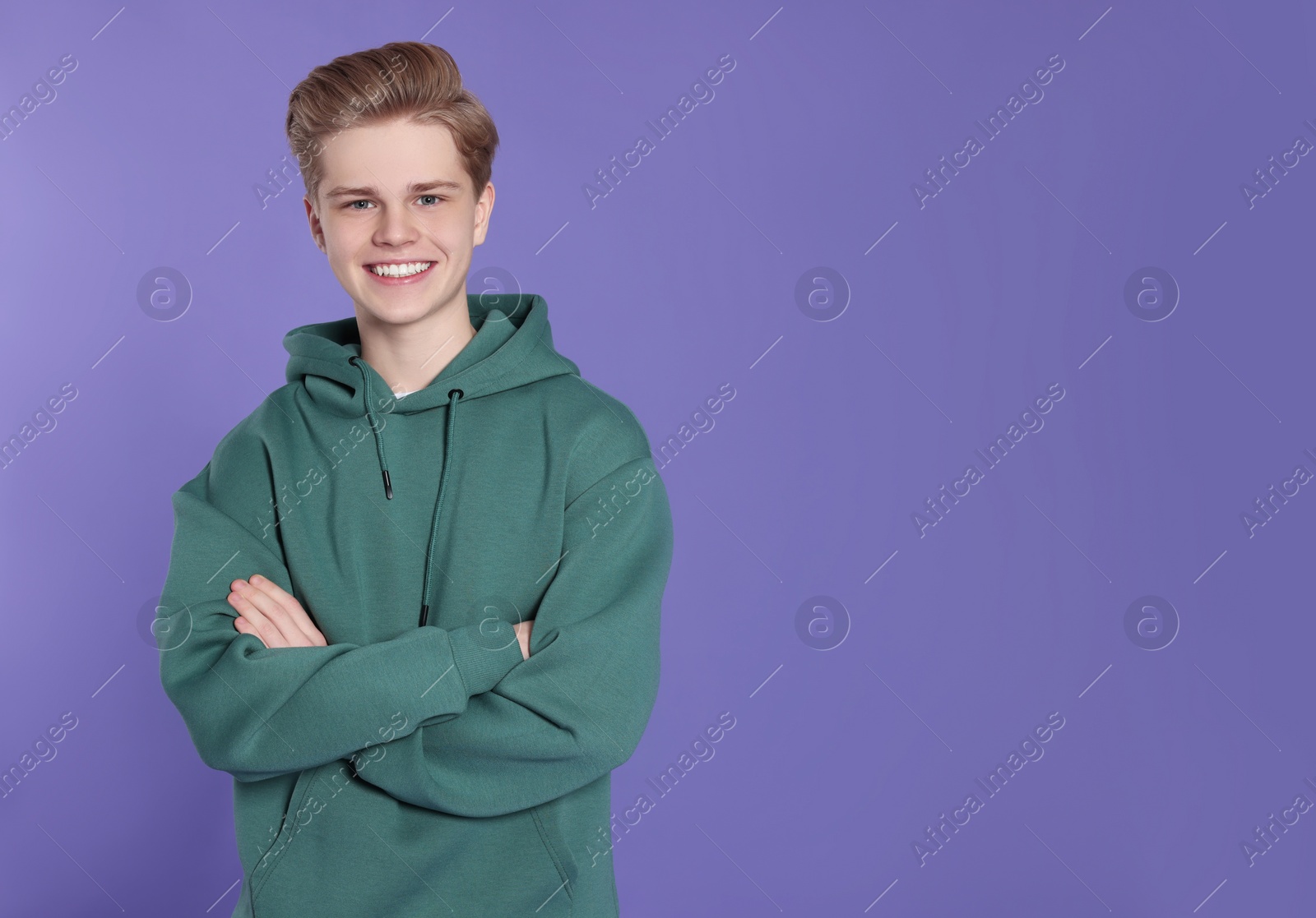 Photo of Portrait of teenage boy on purple background. Space for text