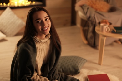 Photo of Young pretty woman with plaid resting at home. Winter season