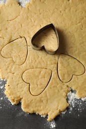 Photo of Making shortcrust pastry. Raw dough and cookie cutter on grey table, top view