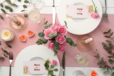 Romantic table setting with flowers and candles, flat lay